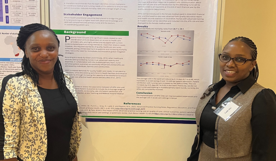 Two researchers standing in front of their poster at a conference.